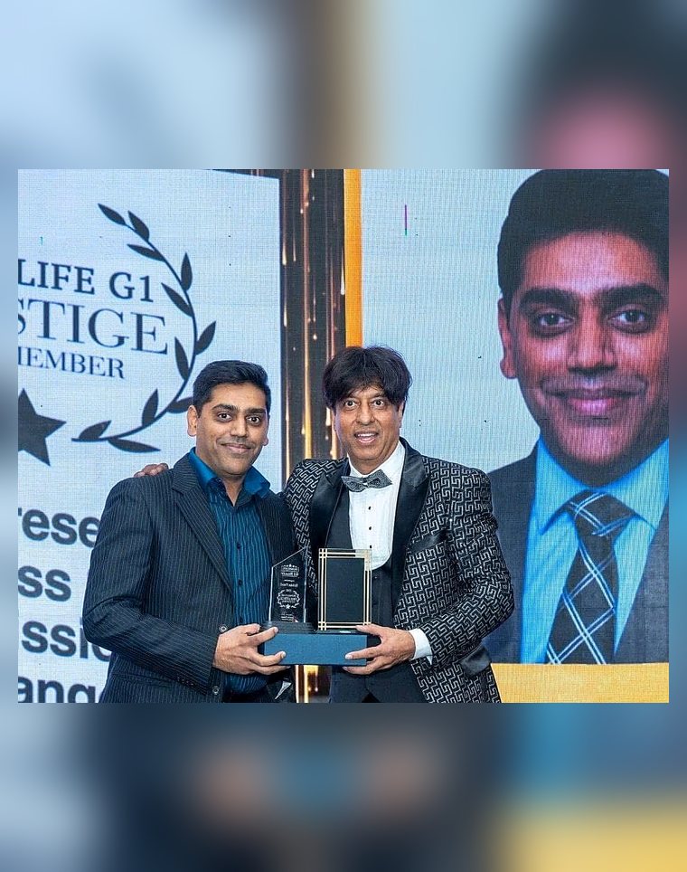 Robin Patel receiving an award, with a HomeLife G1 Prestige Club Member screen behind him.